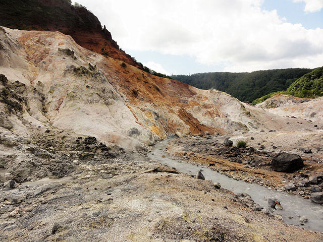 地獄の底へと続く散策路は、三途の川ならぬ、灰白色に染まった温泉が流れる川も渡ります