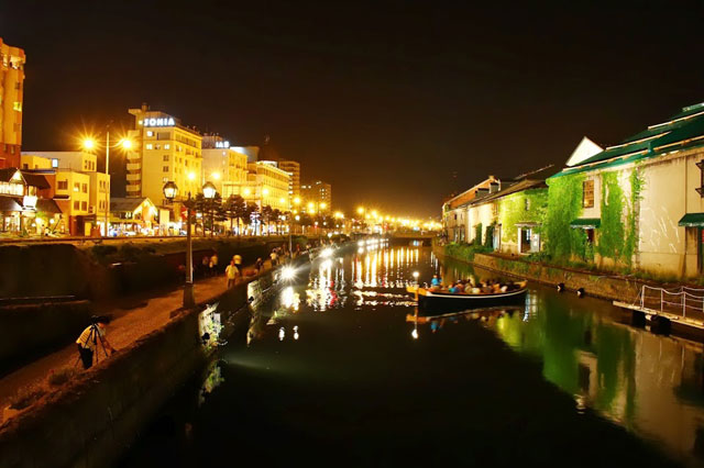 步道上的夜燈在河面上蕩漾，成為夜間遊船的夢幻景色
