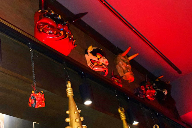 Demon masks and gold clubs are displayed everywhere.