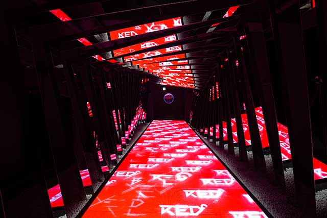 The futuristic entrance to RED TOKYO TOWER, where visitors enter through a hallway of light.