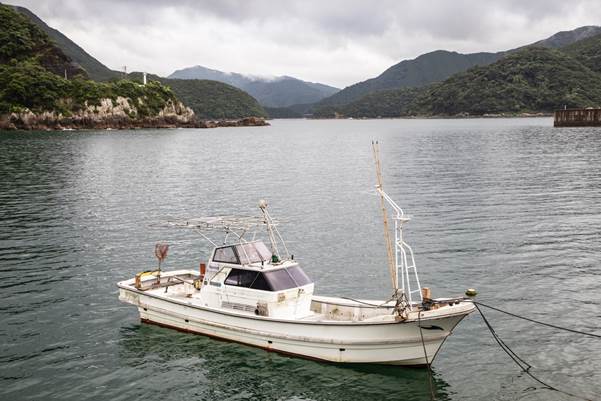 A fishing boat harbored in the town of Sakitsu as a storm brews overhead