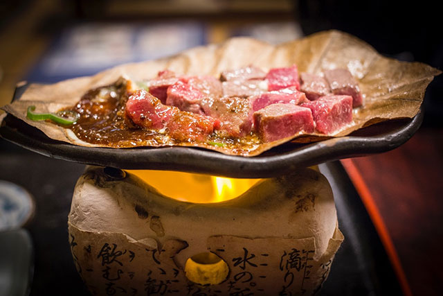 Hida-Gyu steak cooking in miso over an open flame
