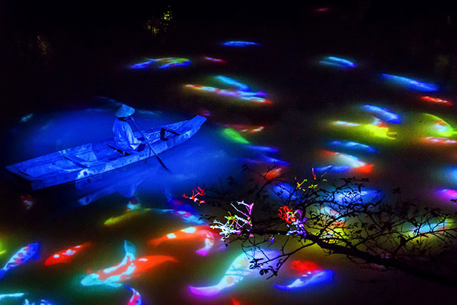 Colorful koi carp fish are projected onto the surface of the water at Mifuneyama Rakuen Park by the production team at Team Lab