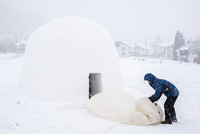 The initial shape of the kamakura is obtained by inflating a large rubber balloon, which is then covered in clumps of snow, that are then patted into shape by the volunteers using their hands and spades. The shape of the kamakura is then maintained on a daily basis