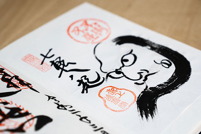 A Daruma ink painting inside a Goshuincho book