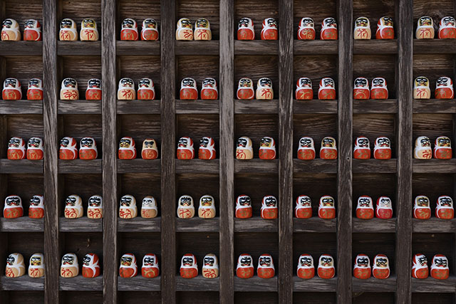 The walls of the temple are lined with Daruma looking in every which direction!
